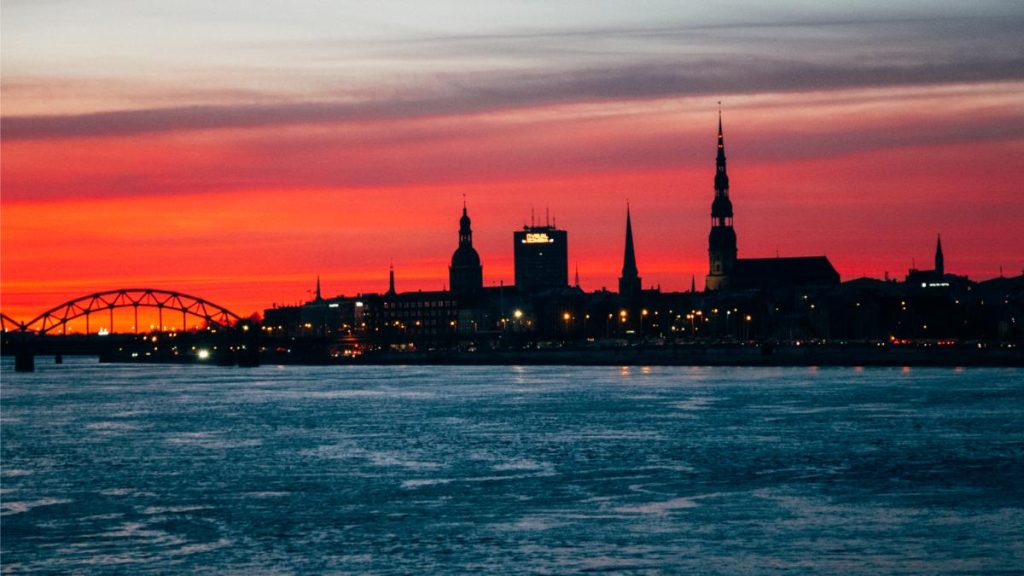 Lush and vibrant sunset puts the city of Riga to sleep, showcasing the skyline as deep dark silhouettes